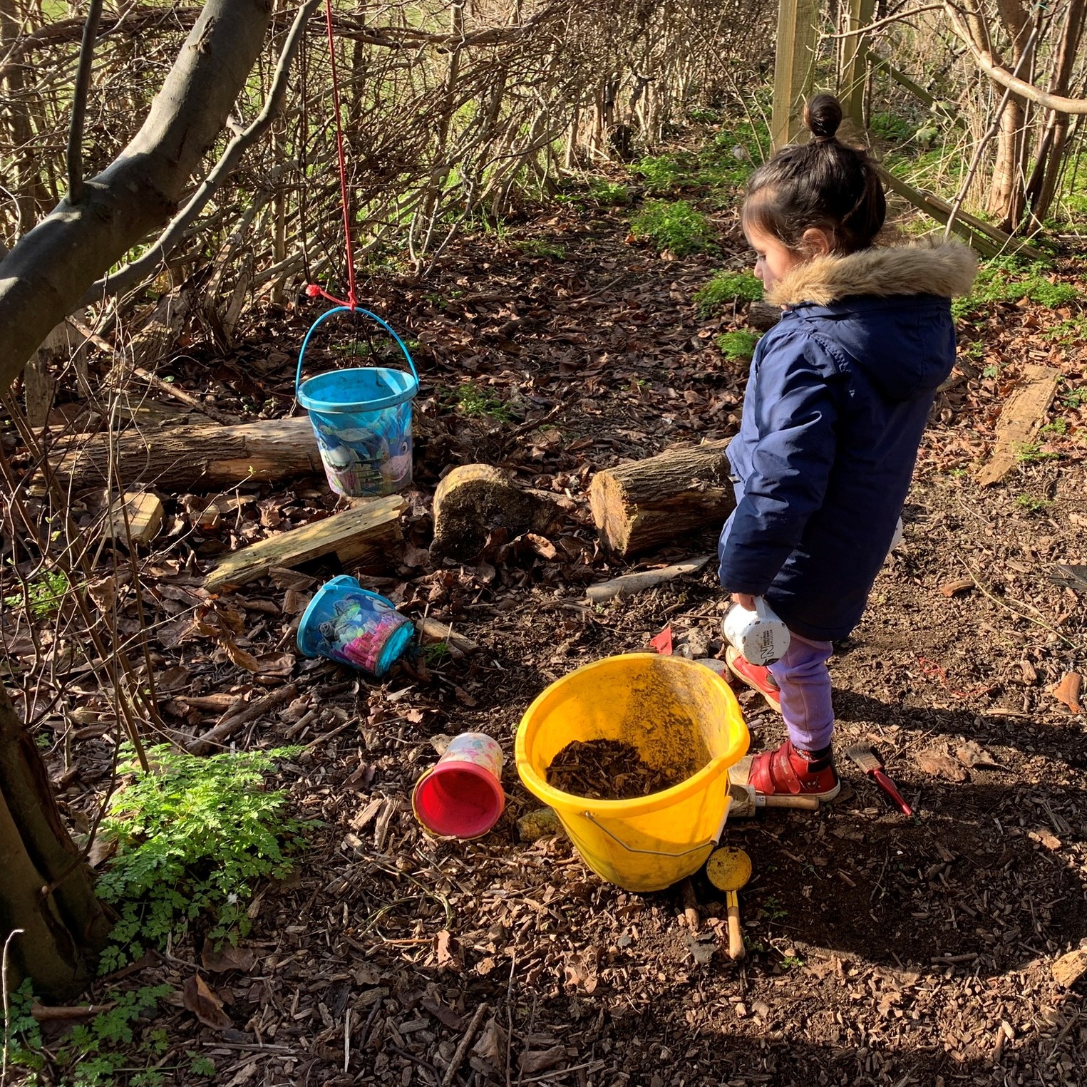 Fun in the mud kitchen under the quince tree near the laid hedge